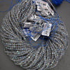 Coiled string of blue beads with labels on a gray background