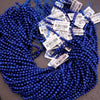 Blue beads with price tags on a gray background