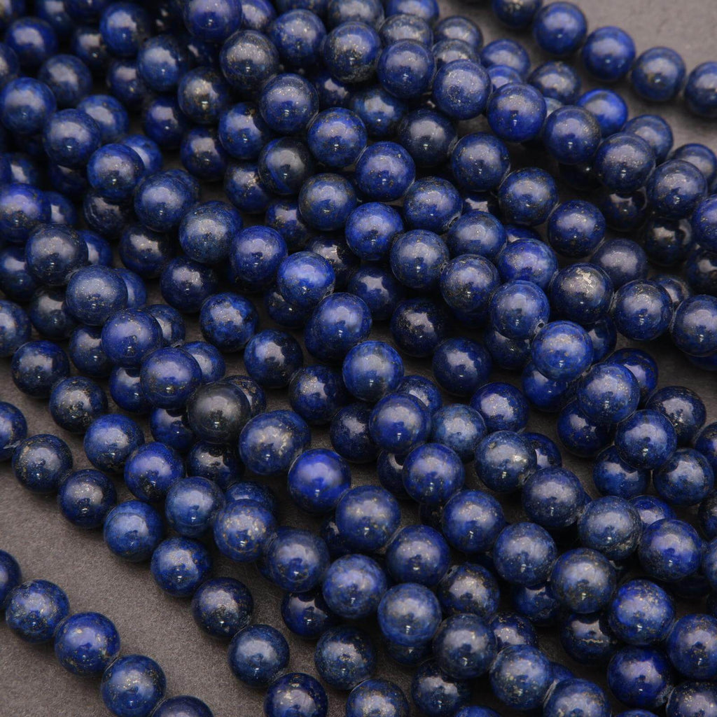Strands of polished lapis lazuli beads displayed closely together.