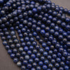 Grouped strands of polished lapis lazuli beads on a flat surface.