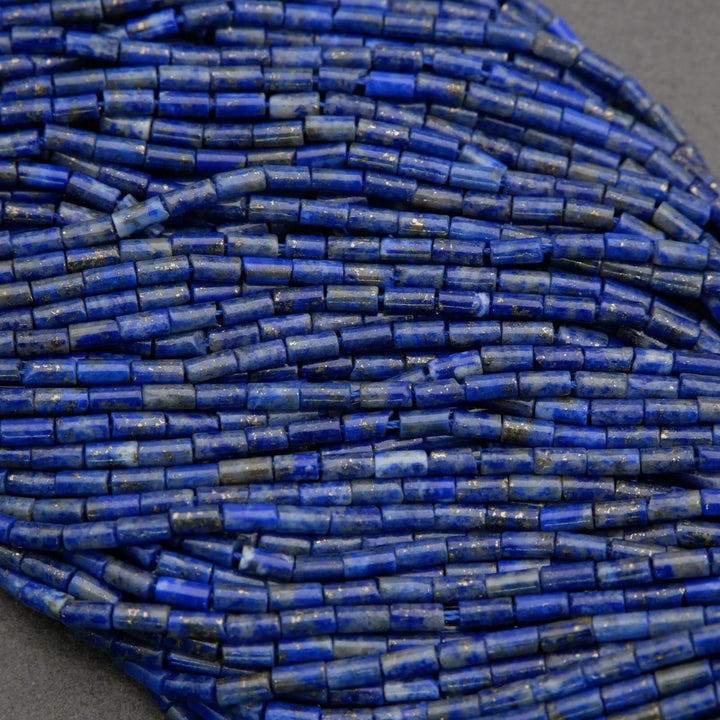 Close-up of a string of blue cylindrical beads on a gray background