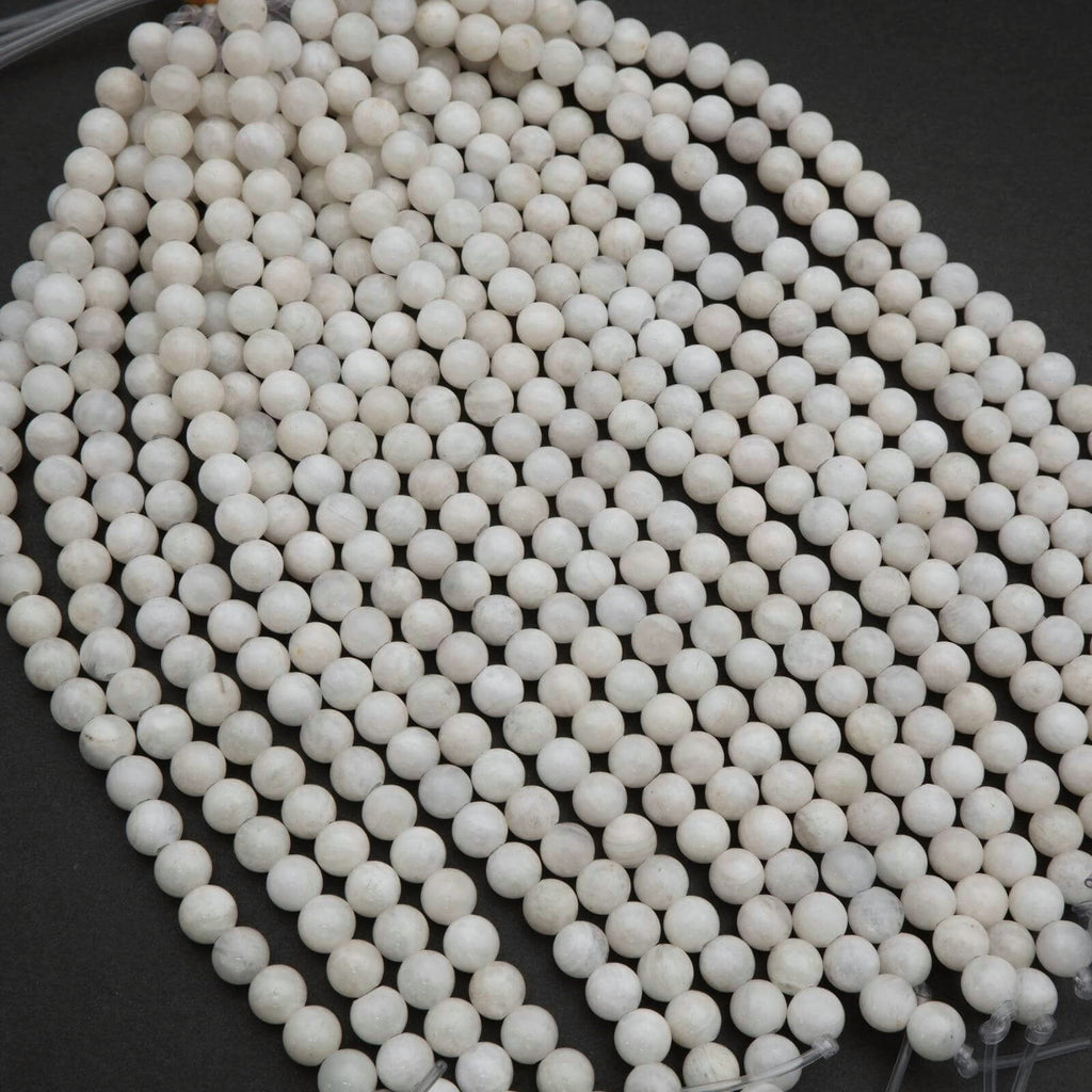 String of white ceramic beads on a dark surface