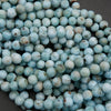 Round Larimar beads with light blue, white, and subtle brown mineral markings