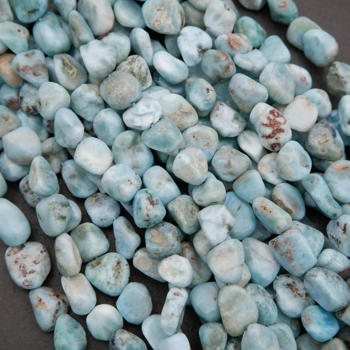 Close-up of turquoise stones with brown spots on a dark surface