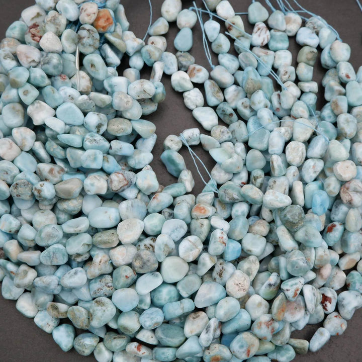 Turquoise stone beads on a string against a dark background