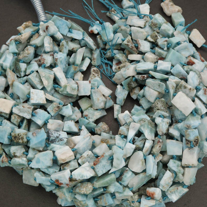 Turquoise stone beads on a string against a dark background