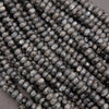 Close-up of dark gray beads on a beige background