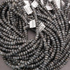 String of dark blue beads with price tags on a gray background