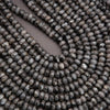 Close-up of dark gray beads on a plain background