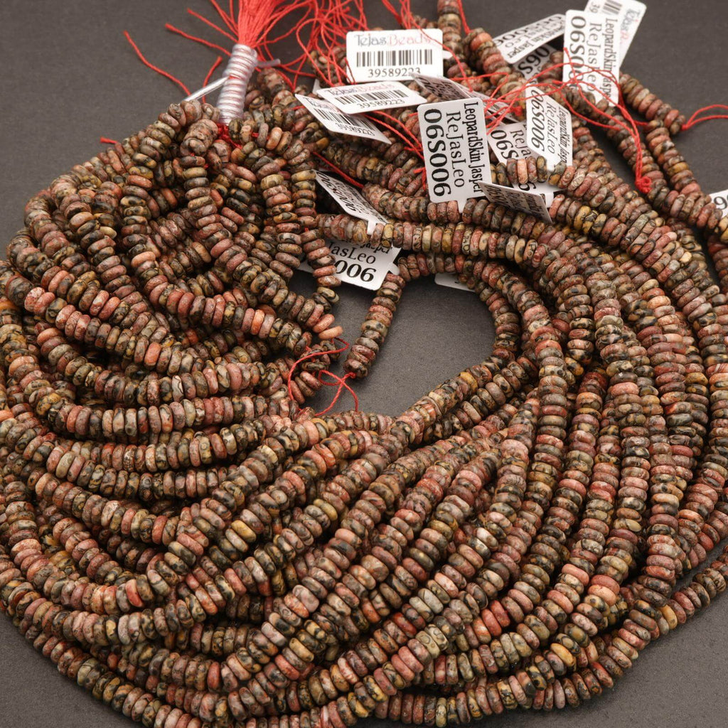 String of multicolored beads with red thread on a gray background