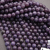 Close-up of purple beads on a gray surface