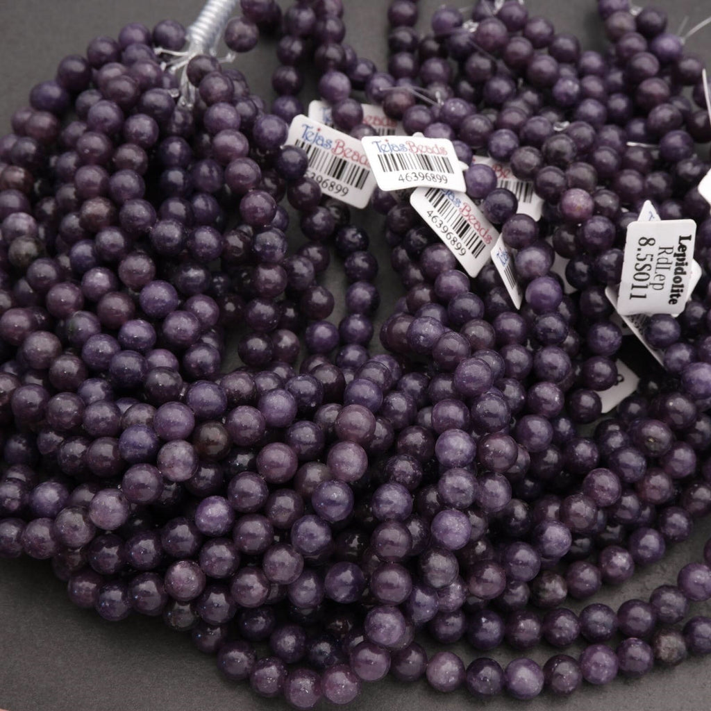 Purple beads with visible tags on a dark background