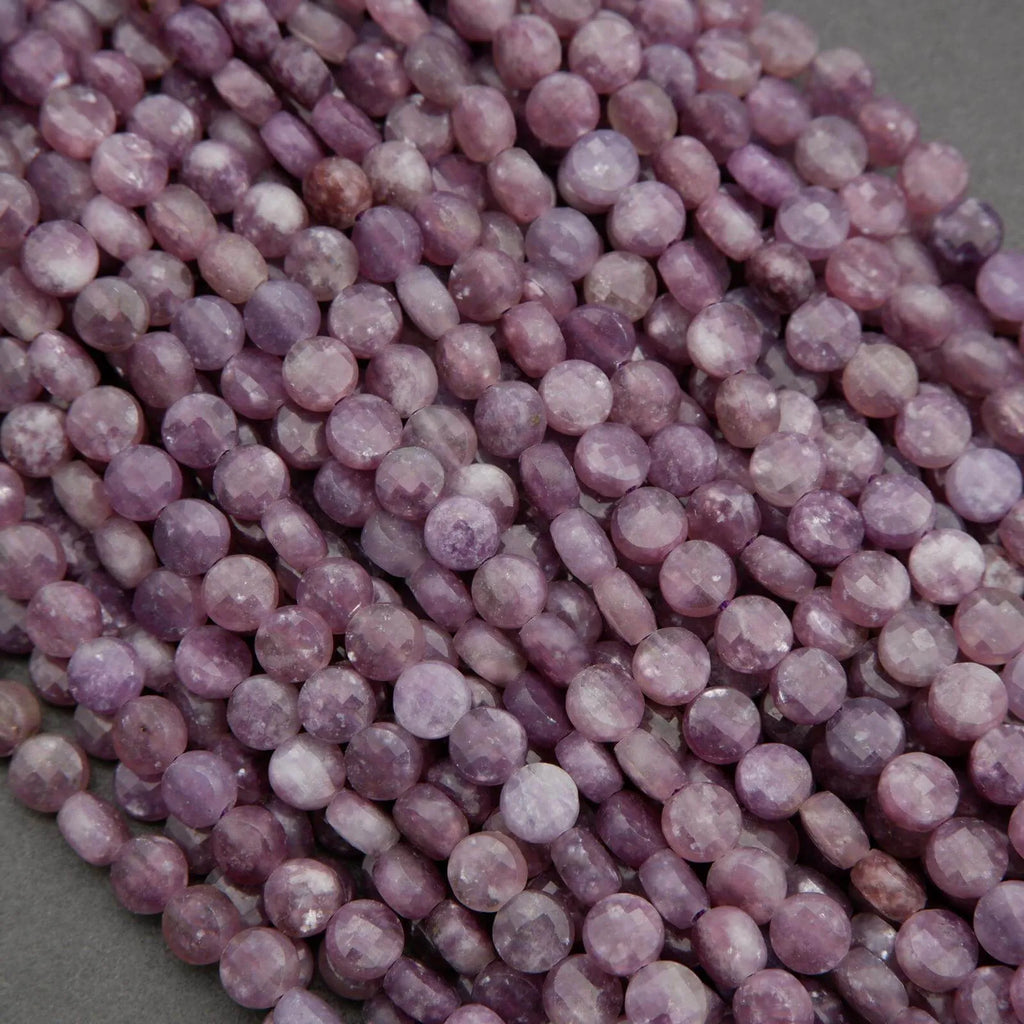 Strands of purple lepidolite beads showing subtle marbling and mineral inclusions