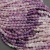 Close-up of purple and pink beads on a gray background