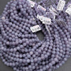 Purple beads with price tags on a gray background