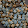 Close-up of faceted gemstone beads with gold spacers on a dark background