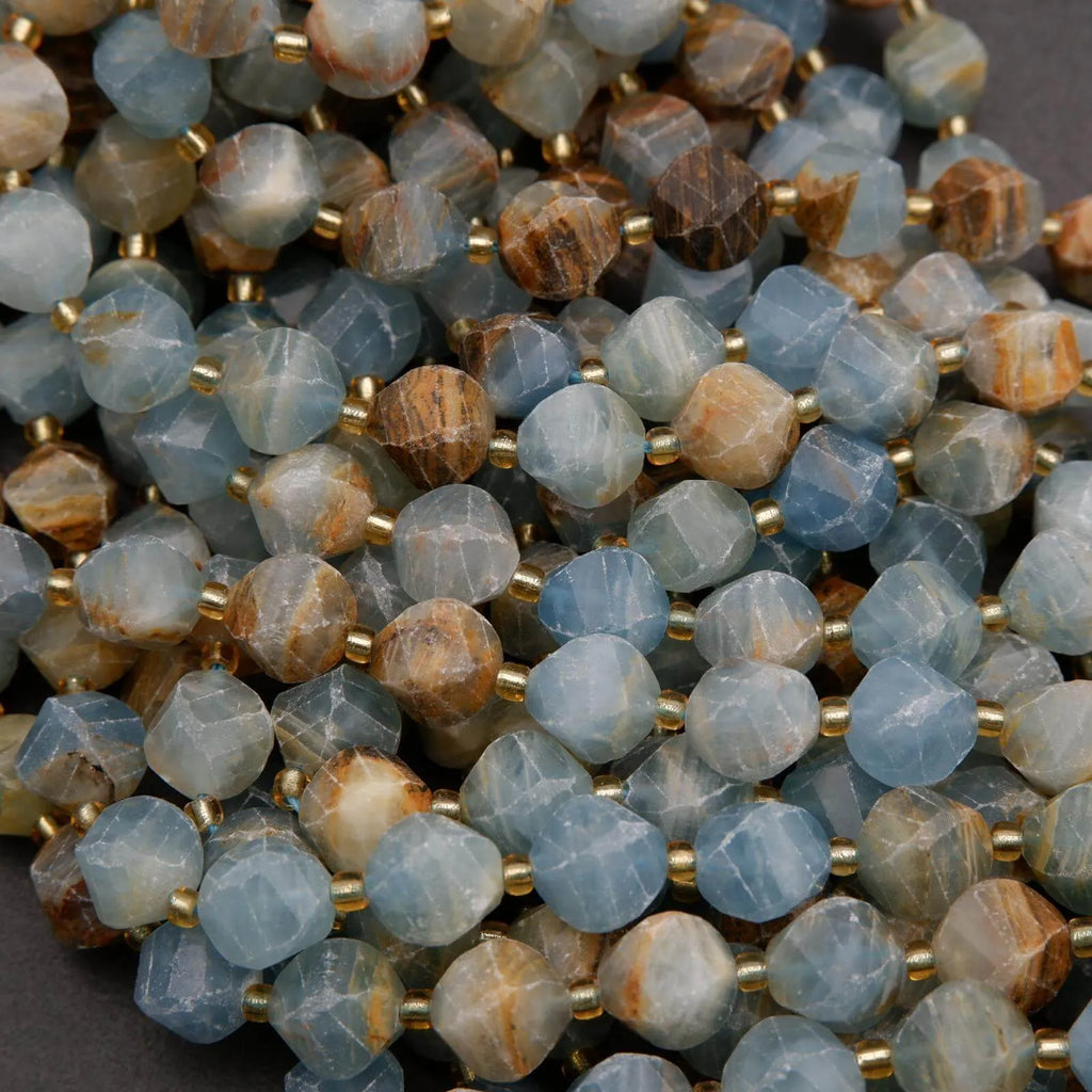 Close-up of faceted gemstone beads with gold spacers on a dark background