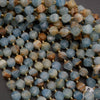 Close-up of a string of blue and brown beads with gold spacers on a dark surface.