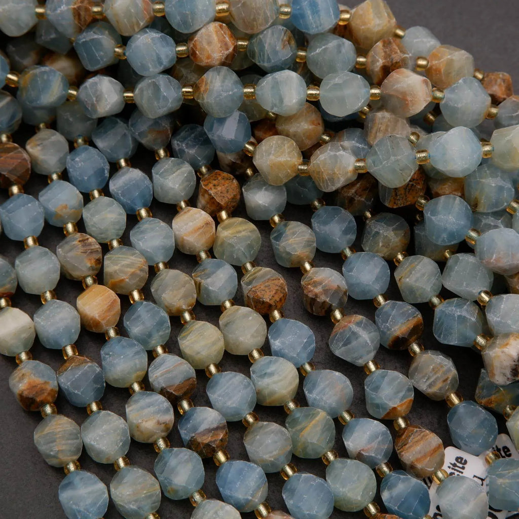 Close-up of a string of blue and brown beads with gold spacers on a dark surface.