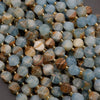 Close-up of multicolored gemstone beads with gold spacers on a dark background