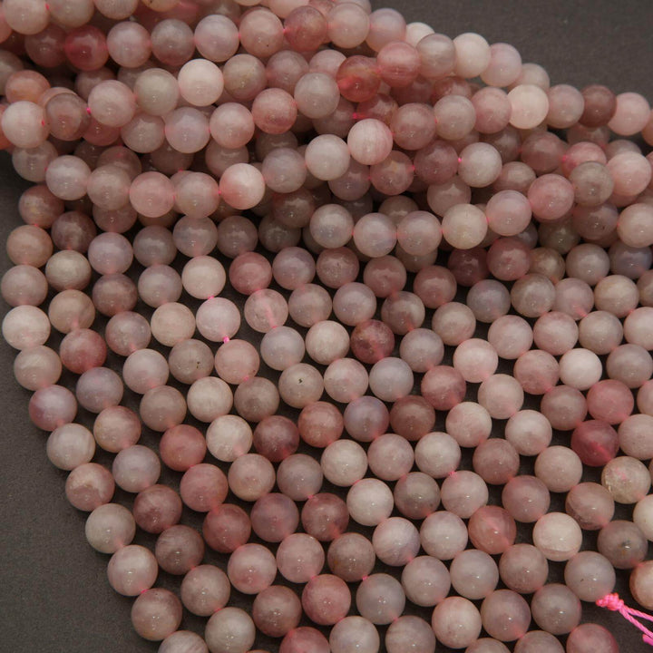 Close-up of pink and white marbled beads on a dark background