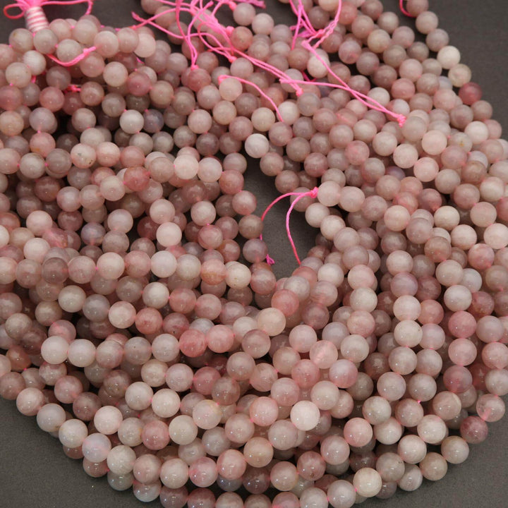 Close-up of pink beads on a string against a dark background