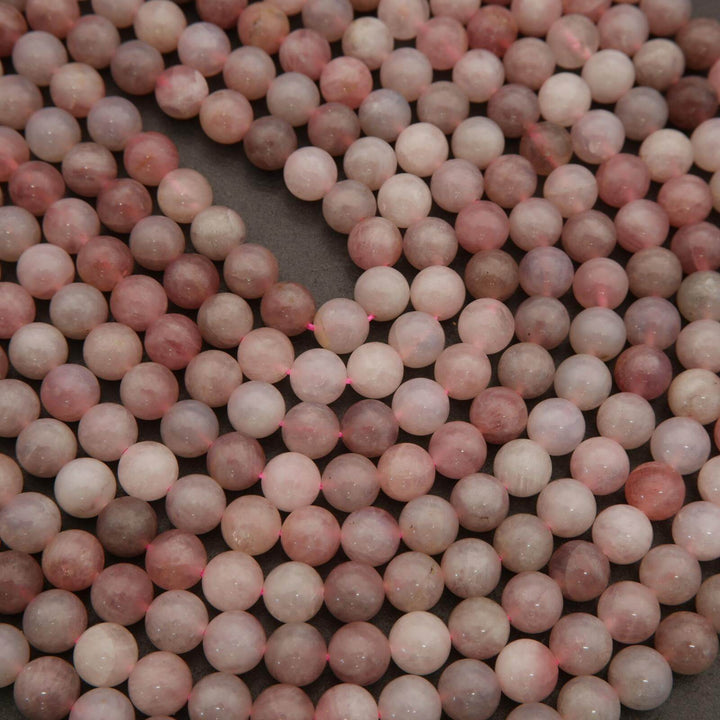 Close-up of pink and white beads on a dark surface