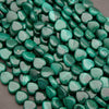Green heart-shaped beads on a gray surface