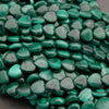 Close-up of green heart-shaped beads on a dark background