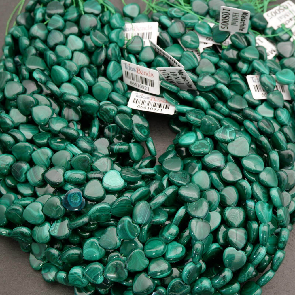 Green heart-shaped beads with labels on a gray background