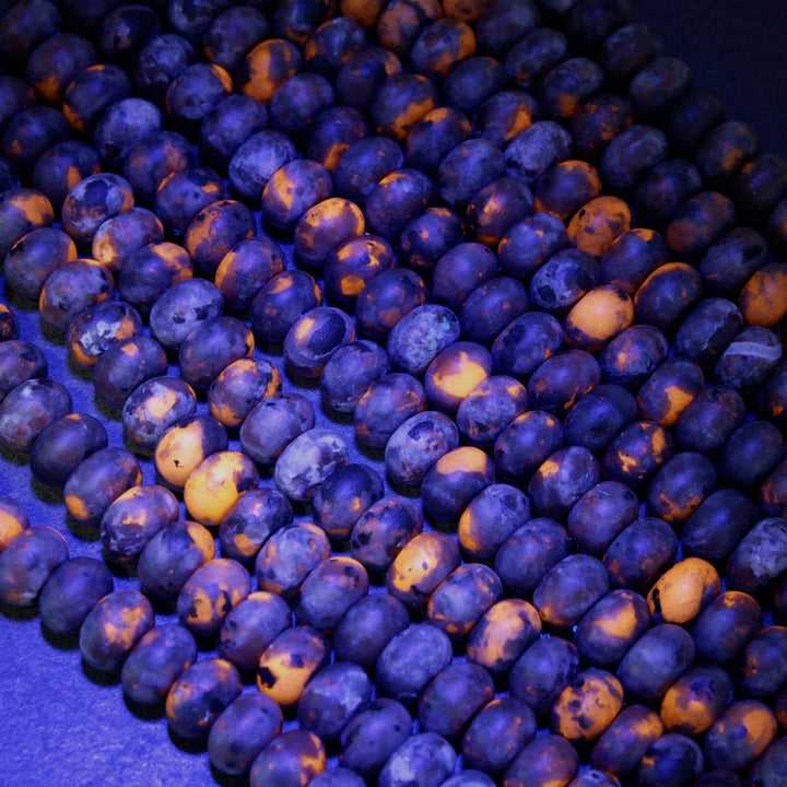 Matte Yooperlite rondelle beads with fluorescent orange patches under blacklight