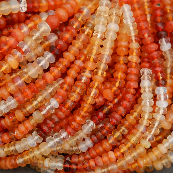 Close-up of faceted fire opal gemstone beads showing high clarity and a mix of sunset orange and honey yellow tones.