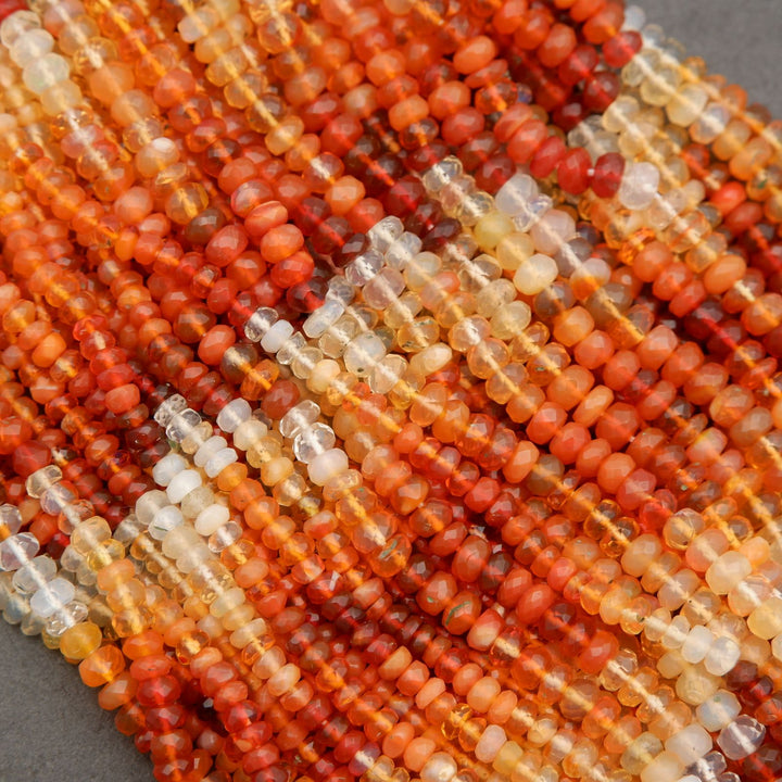 Multiple strands of mexican fire opal rondelle beads arranged in a textured pattern for jewelry making.