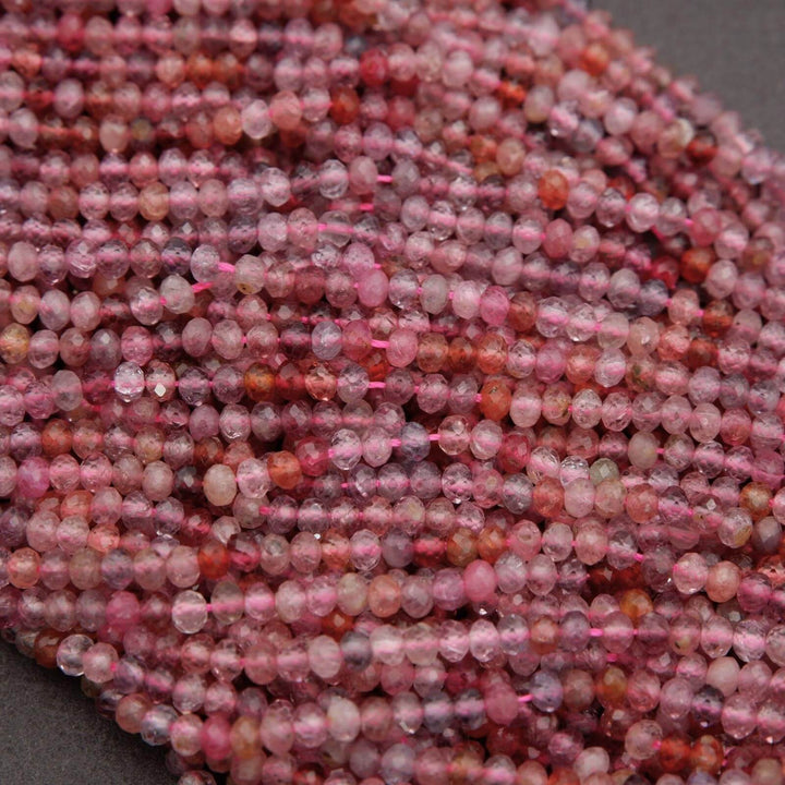 Close-up of a string of pink and red beads on a dark background