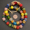 Colorful beaded bracelet with a penny for scale on a gray background