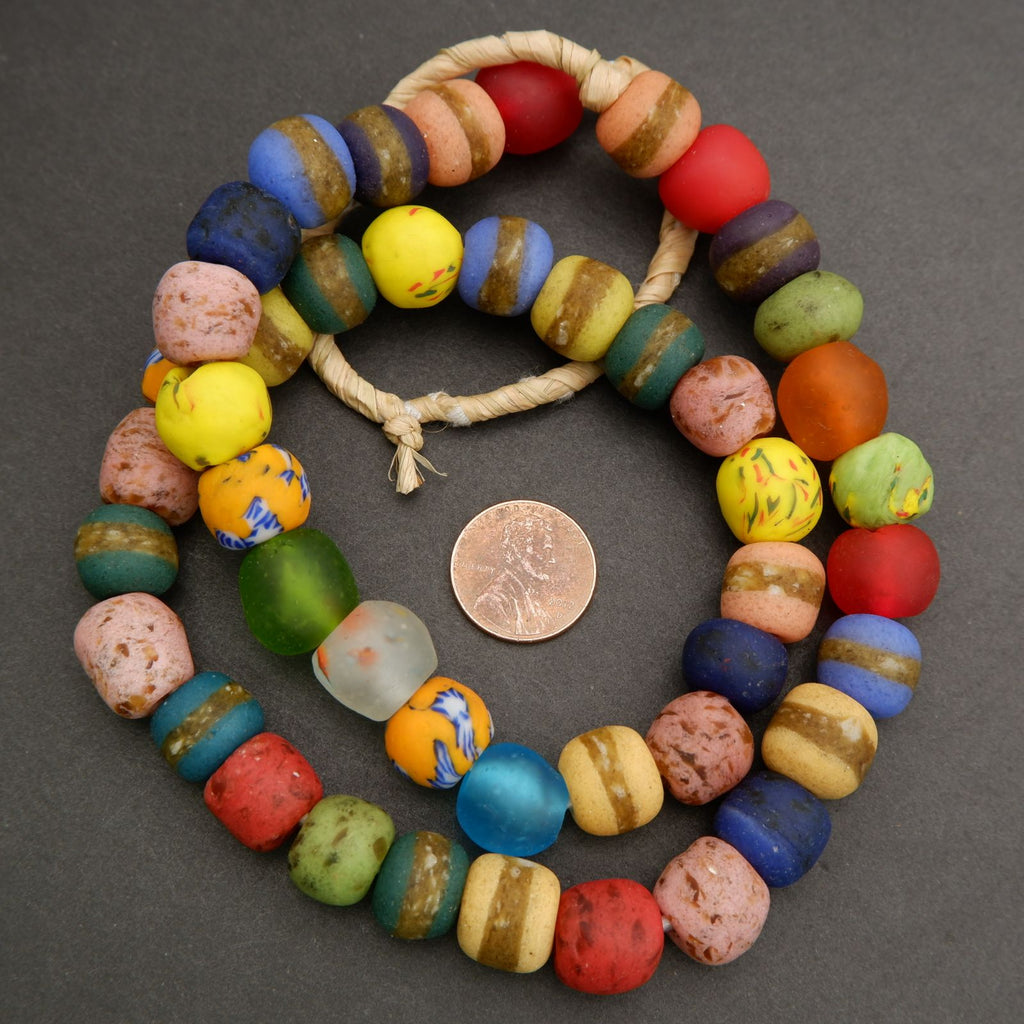 Colorful beaded bracelet with a penny for scale on a gray background
