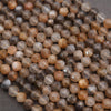 Close-up of faceted gemstones in brown and gray tones.