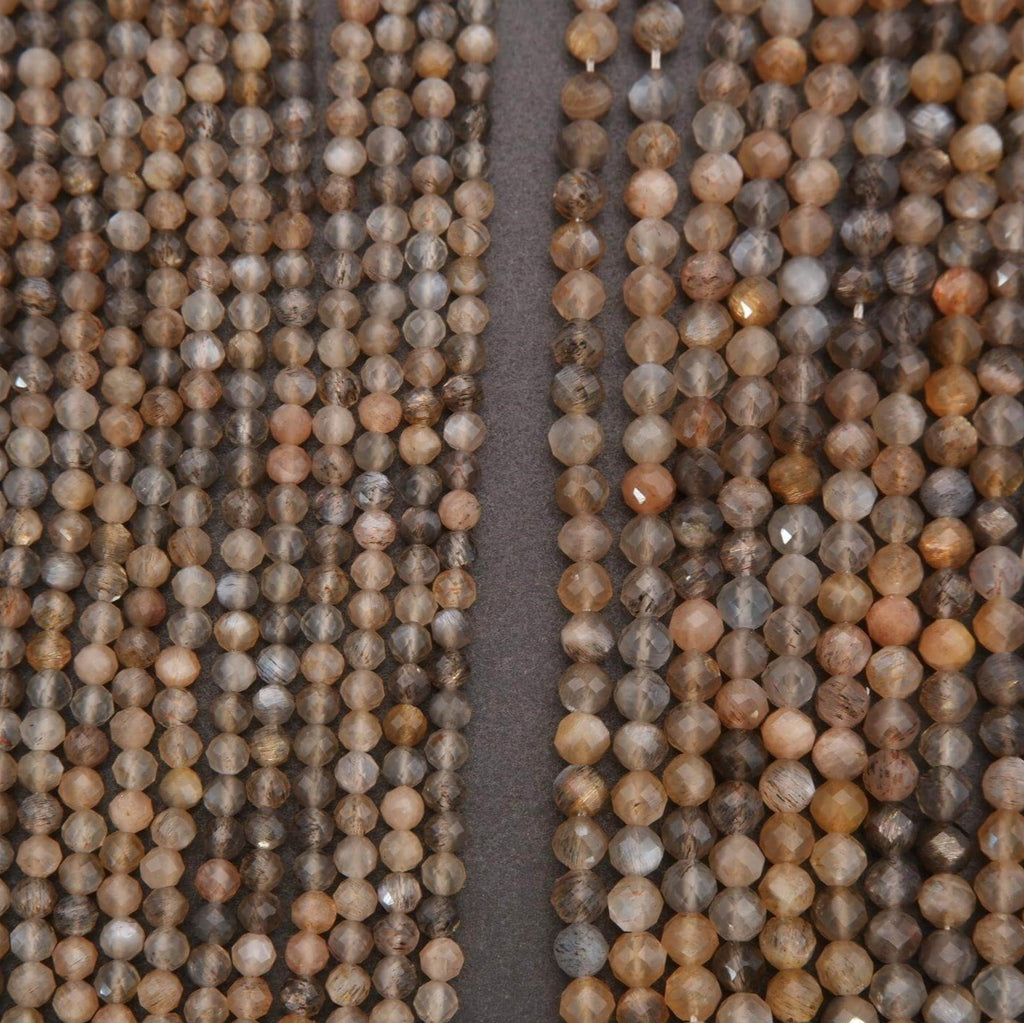 Close-up of two strands of brown and gray beads on a dark background