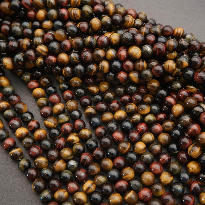 Close-up of a string of multicolored tiger eye beads on a gray background