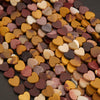 Close-up of a pile of multicolored heart-shaped objects on a dark background