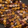 Collection of heart-shaped wooden beads in various colors on a dark surface