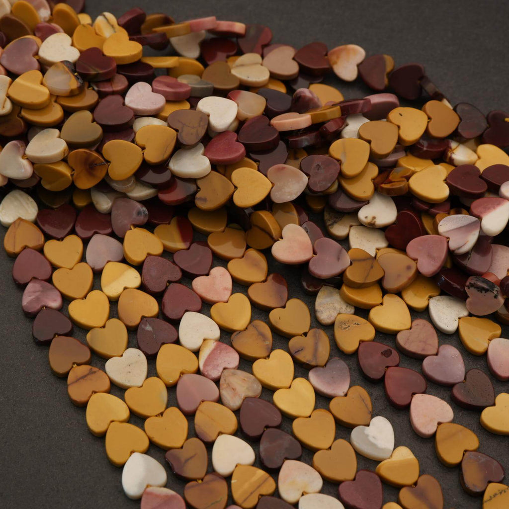 Heart-shaped beads in various colors on a dark surface