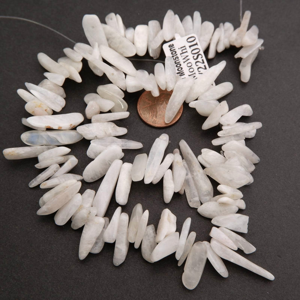 White stone chips arranged in a circular pattern with a penny for scale on a dark background