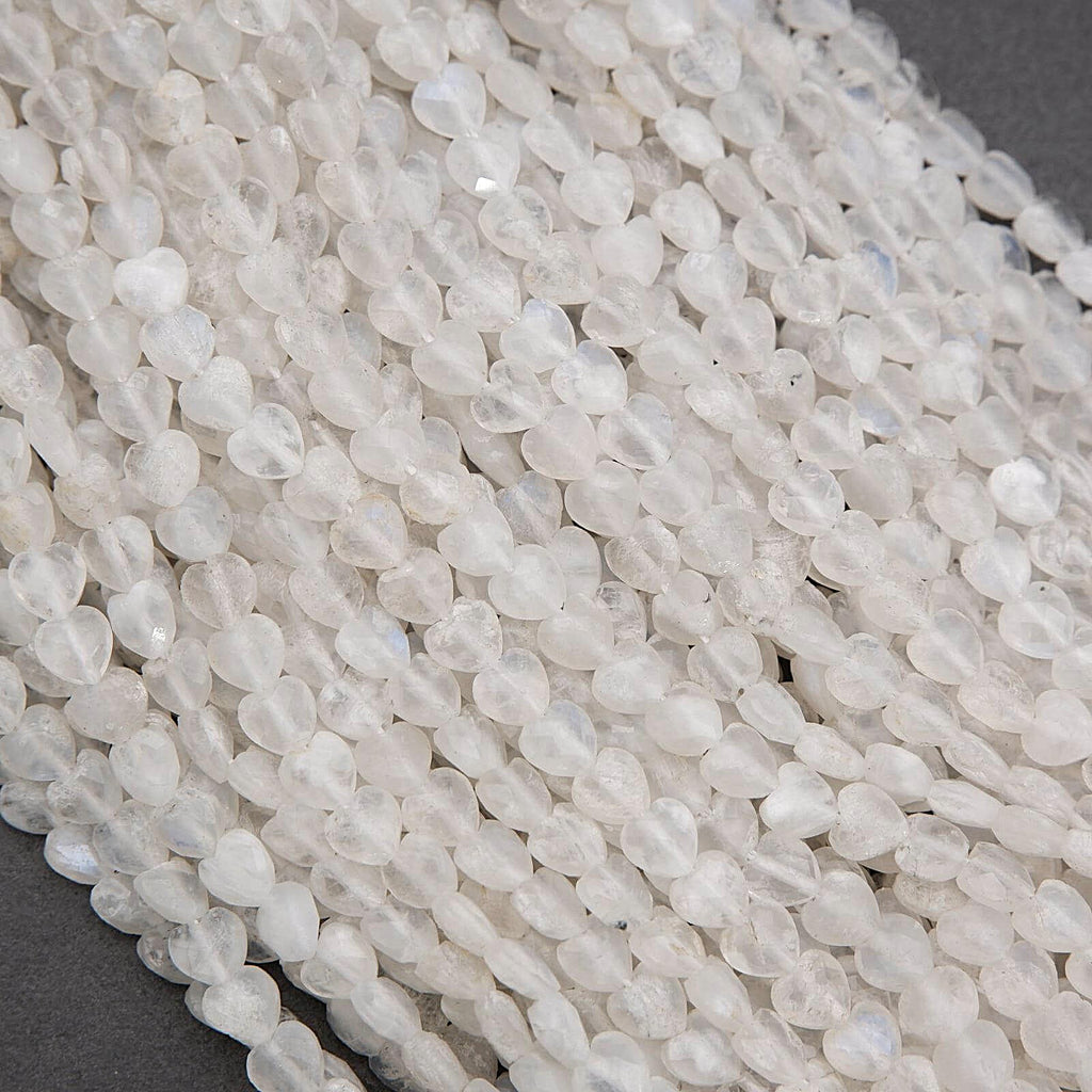 Close-up of white teardrop-shaped beads on a dark surface