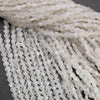 Close-up of white beaded strands on a dark background
