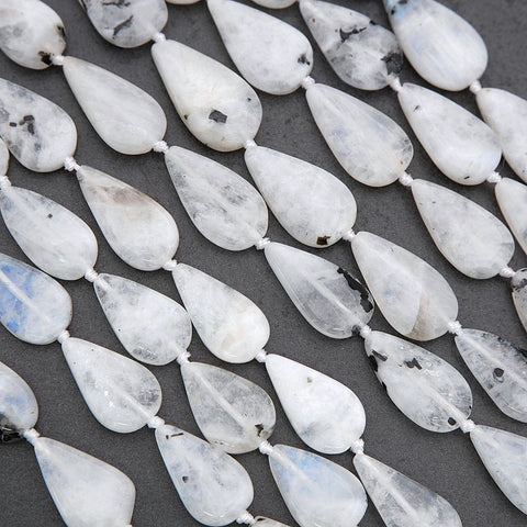 Teardrop-shaped white beads on a dark surface