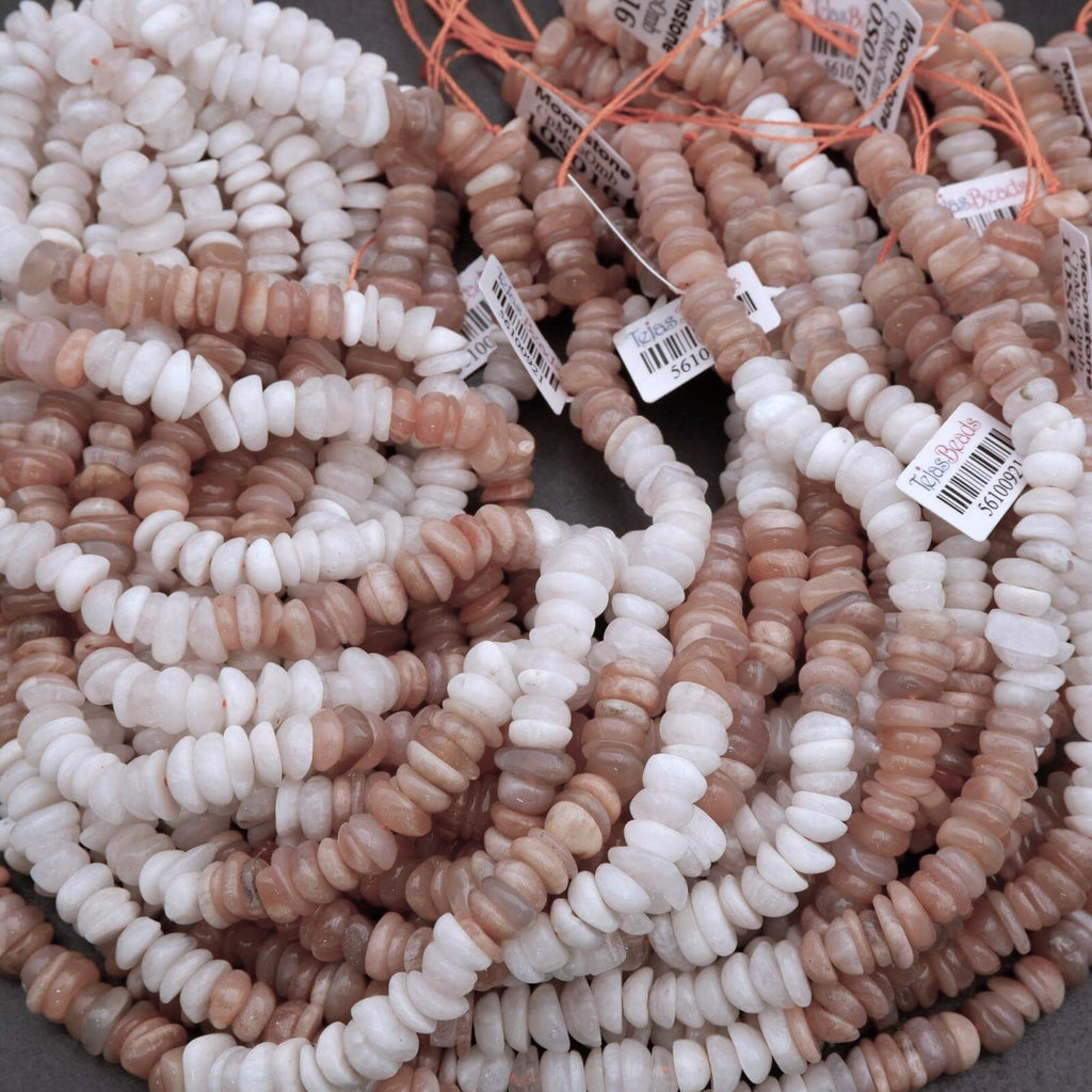 Close-up of strands of pink and white beads with price tags on a gray surface