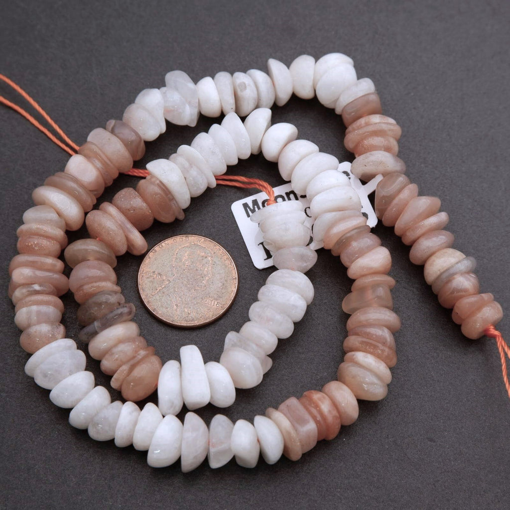 String of multicolored beads with a coin for size comparison on a dark surface