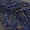 Close-up of blue and brown faceted beads on a dark surface