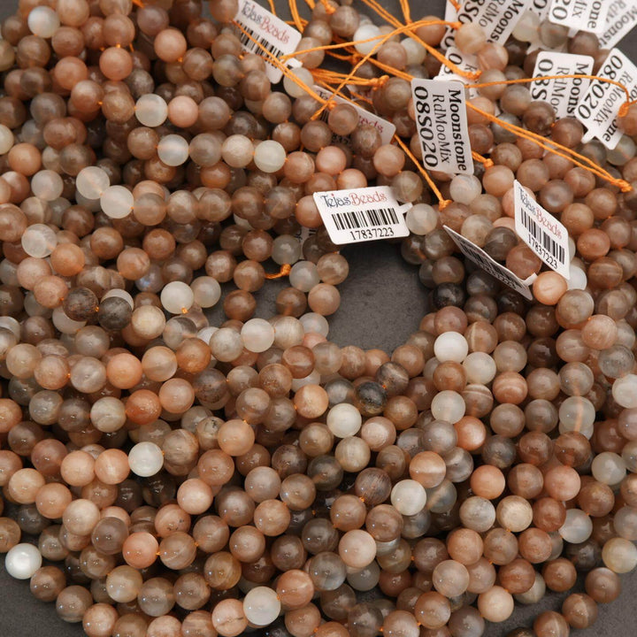 Close-up of brown and beige beads with orange string and price tags.
